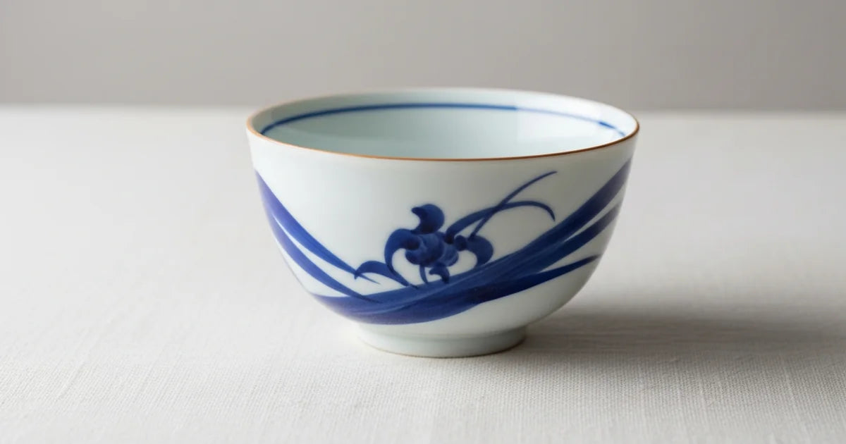 White Japanese porcelain teacup with delicate blue pattern in natural light